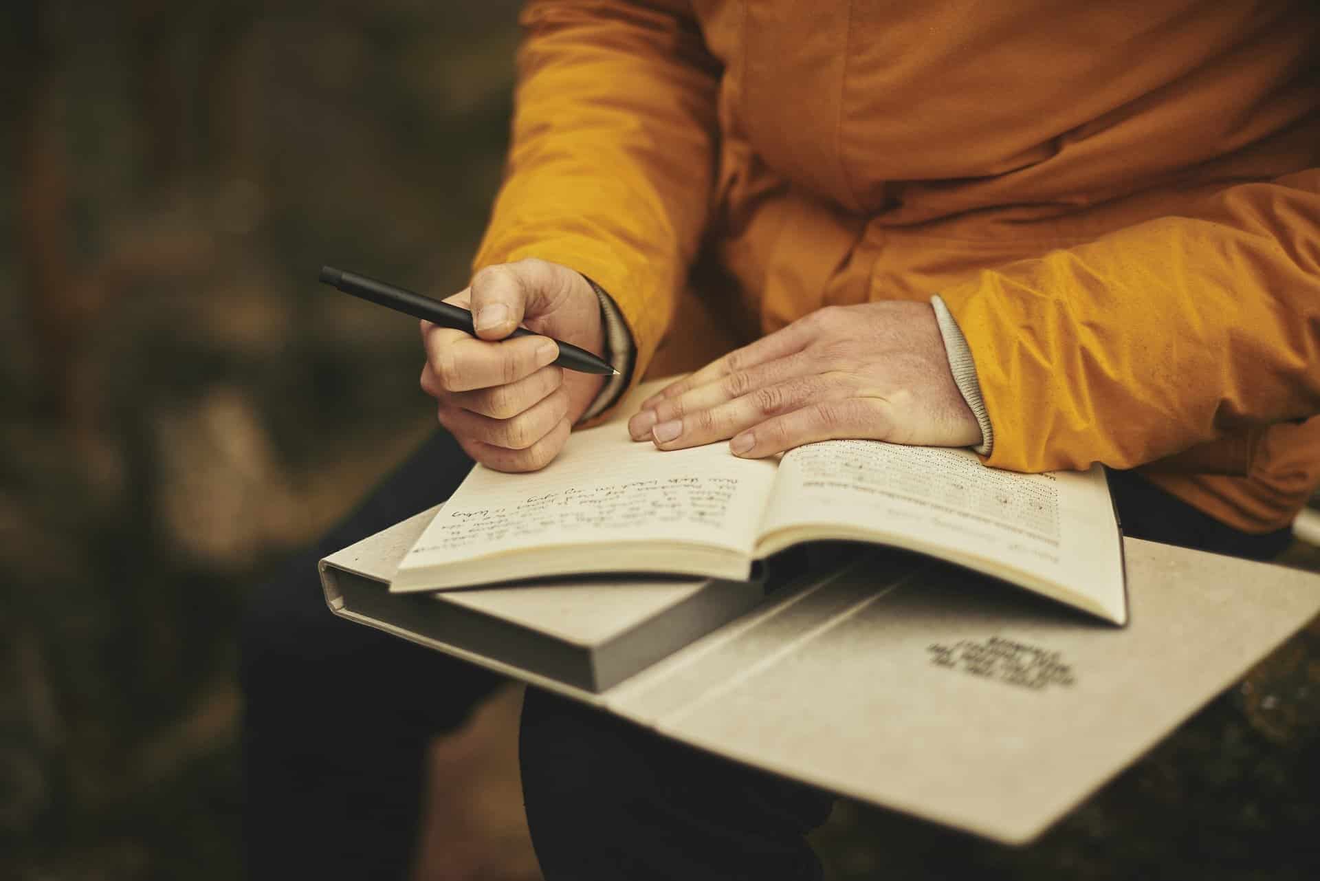 older man writing in self-care journal